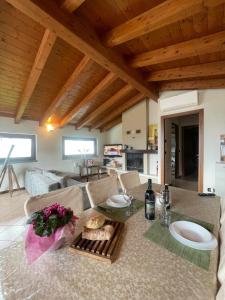 Una cocina y una sala de estar con una mesa con flores. en Ronco Frati, piscina vista lago, en Pisogne