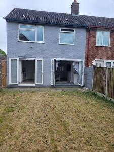 een huis met twee garagedeuren in een tuin bij Comfy Home in Kirkby +6 foto's