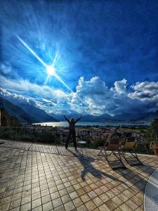 a man standing on a roof with his arms in the sky at Casa Ronco Frati, piscina vista lago in Pisogne +64 photos