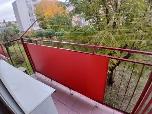 a balcony with a red railing and a white bench at Mieszkanie Chopina Kraśnik in Kraśnik
