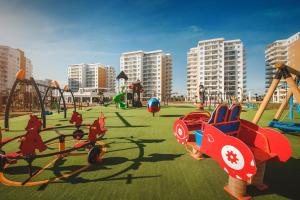 a playground in a city with play equipment and buildings at Caesar Resort Lovely & Cozy 1 Bedroom Home, with Pools & Spas in İskele