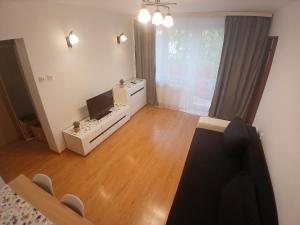a living room with a television and a table and chairs at Mieszkanie Chopina Kraśnik in Kraśnik