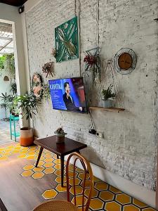 a living room with a table and a tv on a wall at Summergrass B&B in Yogyakarta