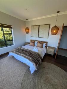 a bedroom with a large bed and a window at Serpentine Views in Hoekwil