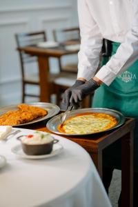 uma pessoa está cortando uma pizza em uma mesa em Hotel Minas Gerais em Poços de Caldas