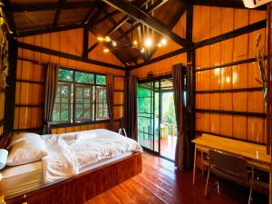 a bedroom with a bed and a table in a room at Flower hill 180 in Chiang Rai
