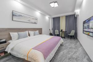 a bedroom with a large bed and a table at Park Hotel in Xiamen