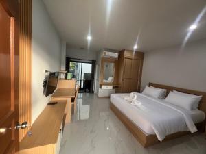 a bedroom with a bed and a television in it at J2 Airport Mansion in Thalang +16 photos