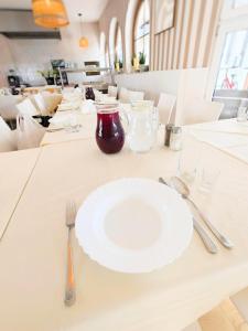 a table with a white plate and fork and knife at Motel Rest in Przemyśl