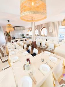 a dining room with white tables and white chairs at Zajazd Rest in Przemyśl