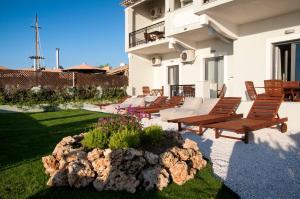 patio z leżakami i ogrodem skalnym w obiekcie Hyacinthus-Cressida Seaside Apartments w Acharavi