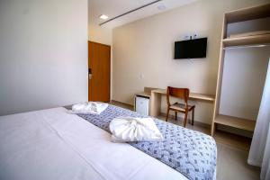 a bedroom with a bed and a chair and a television at MLG Hotel in Mogi das Cruzes +28 photos