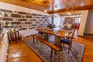 a dining room with a table and a stone wall at Quinta da Espadana in Povoação