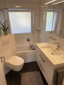 a white bathroom with a toilet and a sink at Erlachoase in Leinfelden-Echterdingen +51 photos