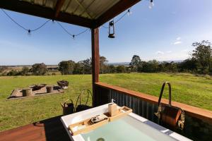 a bathroom with a sink and a view of a field at The Bunker Malniri Park in Wilberforce +7 photos