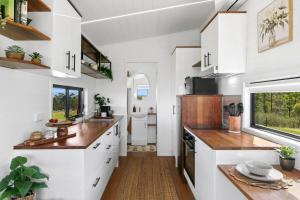 a kitchen with white cabinets and a window at The Bunker Malniri Park in Wilberforce