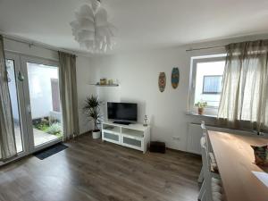 a living room with a tv on a white cabinet at Erlachoase in Leinfelden-Echterdingen