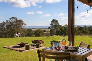 a picnic table in a field with a horse in the background at The Bunker Malniri Park in Wilberforce