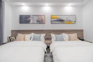 two beds in a room with white walls at Park Hotel in Xiamen +8 photos