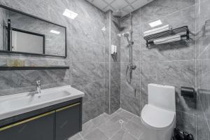 a bathroom with a toilet and a sink and a mirror at Park Hotel in Xiamen