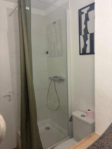 a shower with a glass door next to a toilet at Le charmant Jules Julien parking privé in La Celle-sous-Gouzon