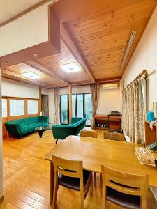 un salon avec une table et des meubles verts dans l'établissement Sky House R1, à Kawagoe