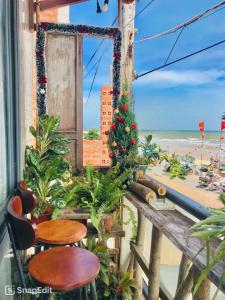 a balcony with a christmas tree and chairs and the beach at Homestay Bảo Nhi in Chợ Phước Hải