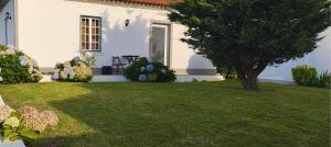 une maison blanche avec une cour arborée dans l'établissement Casa Milhafre 2, à Praia da Vitória