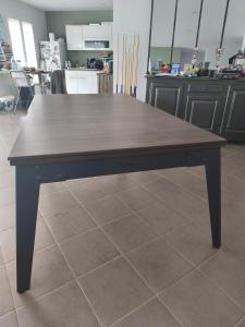 une table en bois assise au-dessus d'un sol carrelé dans l'établissement Chez celine, à Villieu