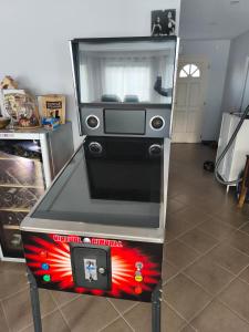 un distributeur automatique rouge, blanc et noir dans une pièce dans l'établissement Chez celine, à Villieu