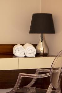 a table with a lamp and two towels on it at Hotel Kamieniczka in Legnica
