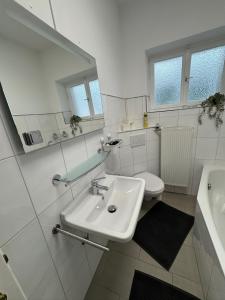 une salle de bain blanche avec un lavabo et des toilettes dans l'établissement Frankfurter 21 Haus - 2 WE, 2 Küchen, 2 Bäder, 6 SZ, 19 Betten, à Siegburg 19 autres photos