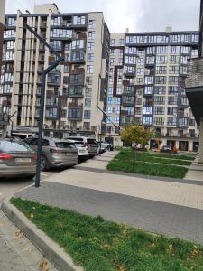 a street with cars parked in front of tall buildings at Апартаменты у новому будинку біля Либідь Плази-Ощадбанк in Khmelʼnytsʼkyy