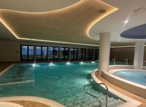 a large swimming pool in a building with a large swimming pool at Premium Apartament PINEA Pobierowo in Pobierowo