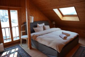 une chambre avec un lit dans une pièce avec des fenêtres dans l'établissement Chalet Rossier Mayens de Sion aux 4 Vallées, à Agettes