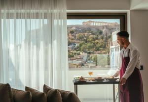 a man standing in a room with a table with food at Eternity Athens in Athens