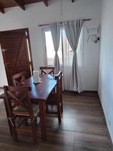 a wooden table and chairs in a room with a window at Apart Atlántida I in Santa Clara del Mar +1 photo