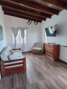 a living room with a bed and a couch and a tv at Apart Atlántida I in Santa Clara del Mar
