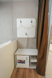 a small refrigerator with a shelf in a room at ИксаОтель in Shymkent