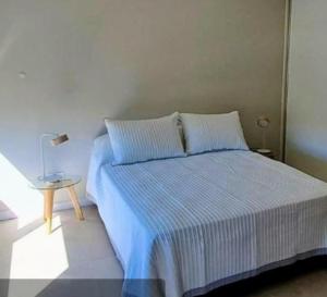 a bedroom with a bed and a lamp on a table at Casa del campo in Mar del Plata