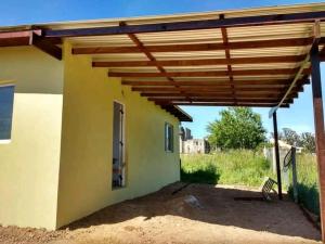 a wooden pergola on the side of a house at Casa del campo in Mar del Plata