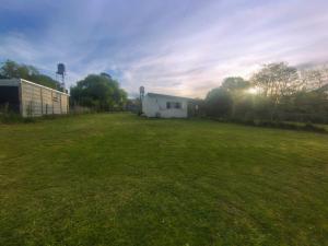 a large grass field with a building in the background at Casa del campo in Mar del Plata