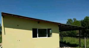 a small house with a window in a field at Casa del campo in Mar del Plata +1 photo