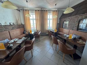 un restaurant avec des tables et des chaises et un mur de briques dans l'établissement Pension zum goldenen Anker direkt an der Elbe, à Wittenberge