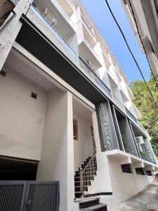 a white building with stairs on the side at Roots & Peaks in Rishīkesh +24 photos