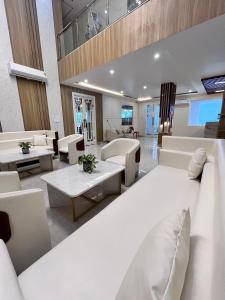 a living room with a large white couch and tables at Roots & Peaks in Rishīkesh