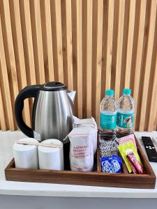 a tray with a tea kettle and other items on a counter at Roots & Peaks in Rishīkesh