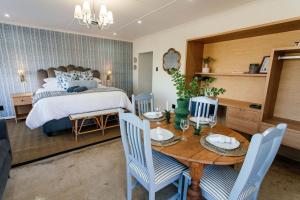 a bedroom with a bed and a table with chairs at 24 Bergview Road apartment in Hilton