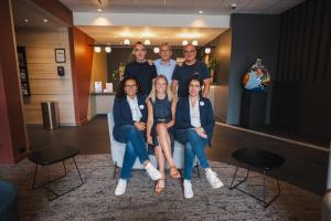 un grupo de personas sentadas en un sofá en Hotel & Aparthotel Casteau Resort Mons Soignies, en Casteau