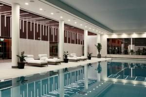 a swimming pool in a building with chairs and a building at Blueground Stratford rooftop nr Olympic Park LON-690 in London